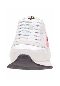 Zapatilla deportiva blanca de ante con acentos rosas, cordones azules y una suela negra texturizada que presenta un logotipo triangular en el talón.
