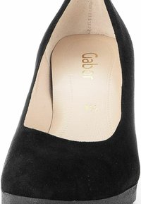 Chaussure à talon haut en suède noir avec un bout fermé, dotée d'une semelle intérieure beige embossée avec "Gabor" et les détails de taille. Texture lisse, design épuré.