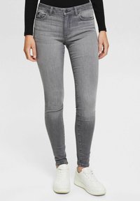 Skinny jeans in gray denim, featuring a standard button and zipper closure, with front and back pockets, and a slight fading detail.