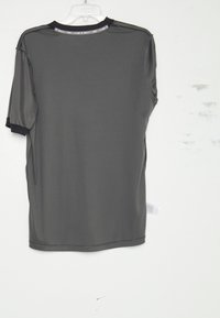 Grijze shirt met korte mouwen, gemaakt van gladde stof. Heeft een ronde hals met zwarte afwerking, zichtbare naden en een zijlabel.