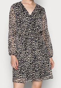 Leopardmuster-Kleid aus durchsichtiger Stoffqualität, V-Ausschnitt, lange Ärmel, tailliert mit einem Gürtel. Die Farben sind Beige, Schwarz und Braun.