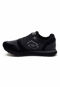 Scarpa sportiva nera realizzata con materiali in mesh e suede, design con lacci, profilo basso, caratterizzata da un logo argentato riflettente e suola testurizzata.