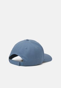 Kék pamut baseball sapka ívelt vízszíjjal, állítható pánttal és varrási részletekkel. A hátsó része nyitott, szellőzőlyukakkal.