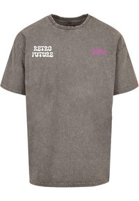 Pelēks pārāk liels kokvilnas T-krekls ar baltu uzrakstu "RETRO FUTURE" priekšpusē un mazu rozā uzrakstu sānos. Īsas piedurknes, apaļa kakla izgriezums.