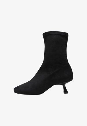 Bottine en suede noire avec un bout pointu, un dessus ajusté et un talon angulé unique. Texture lisse et design minimaliste.