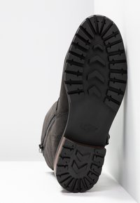 Černé semišové kotníkové boty s texturovanou gumovou podrážkou se zigzagovým vzorem a logem. Boční zip a křivkové detaily prošívání.