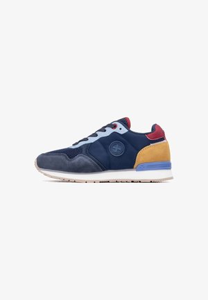 Zapatilla deportiva en azul marino y gris con materiales de ante y malla, con detalles en burdeos y mostaza, logo redondo y entresuela blanca.