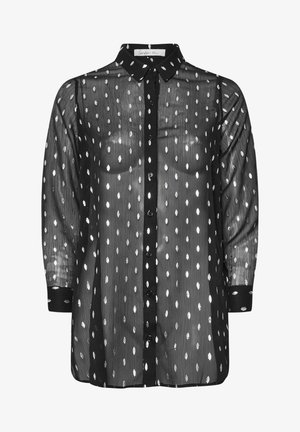 Czarna prześwitująca bluzka z srebrnymi liściastymi wzorami, z przodu na guziki, z kołnierzykiem i długimi rękawami zakończonymi czarnymi mankietami.