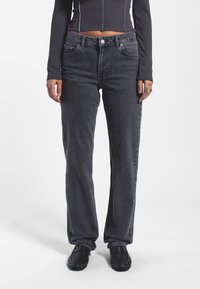 Jeans grigi a gamba dritta con design classico a cinque tasche, realizzati in denim, presentano una leggera texture lavata e accenti di cucitura arancione.