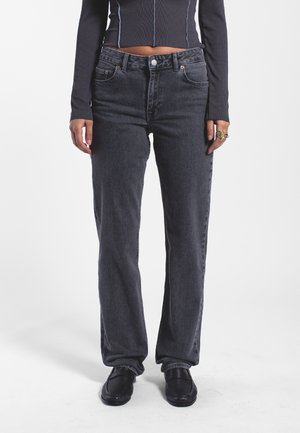 Jeans gris à jambe droite avec un design classique à cinq poches, en denim, présentant une légère texture délavée et des accents de coutures orange.