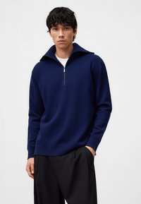 Felpa blu navy realizzata in materiale morbido, con colletto alto, mezza cerniera e vestibilità rilassata. Texture liscia e design minimal.