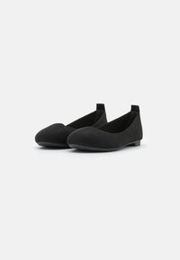 Ballerine in suede nero con punta tonda, profilo basso e tacco minimo. Texture liscia, design semplice e senza decorazioni visibili.