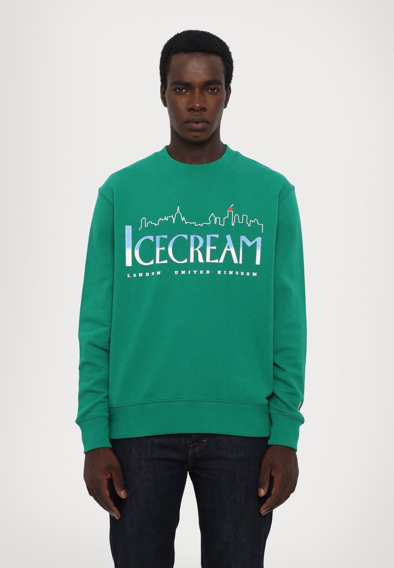 Grøn sweatshirt med rund hals, prydet med "ICECREAM" tekst og skyline grafik i blå og hvid, samt "London United Kingdom" trykt nedenfor.
