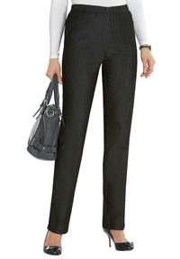 Zwarte rechte broek met een elastische tailleband, gemaakt van gladde stof, gecombineerd met een grijze handtas en zwarte lakleren hakken.