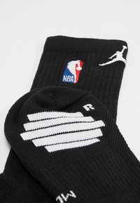 Juodi šaliai su NBA logo, balta Jumpman dizaino detale, su šonkaulio tekstūra ir sustiprintu kulnu. Yra vientisos spalvos ir siuvinėtos detalės.