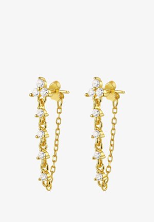 Gouden oorbellen met fijne ketting en kralenaccenten, gedragen aan een oor, met een close-up van gladde huid en lichtbruin haar. Roze manicure zichtbaar.