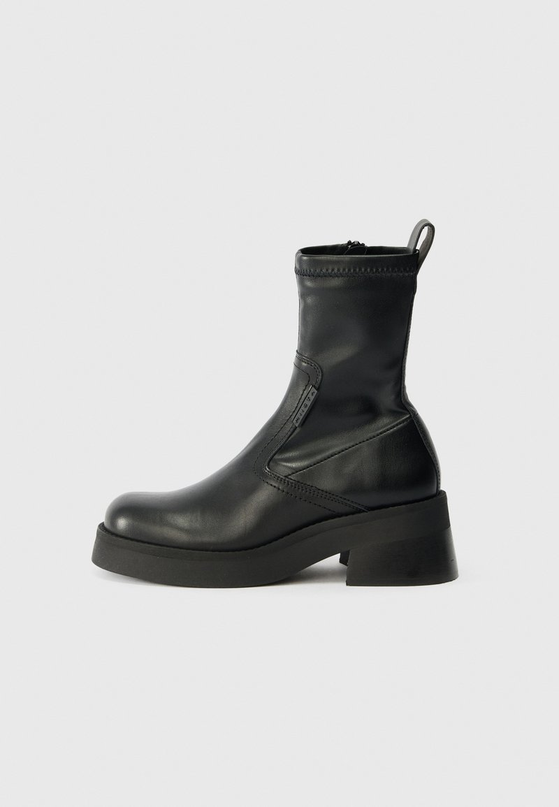 Black leather ankle boots with a rounded toe, side zip closure, low block heel, and clean stitching. Textured surface with a smooth finish.