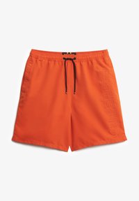 Bañadores de color naranja brillante, fabricados con tejido ligero, que cuentan con una cinturilla elástica con cordón y un logo en relieve en el costado.