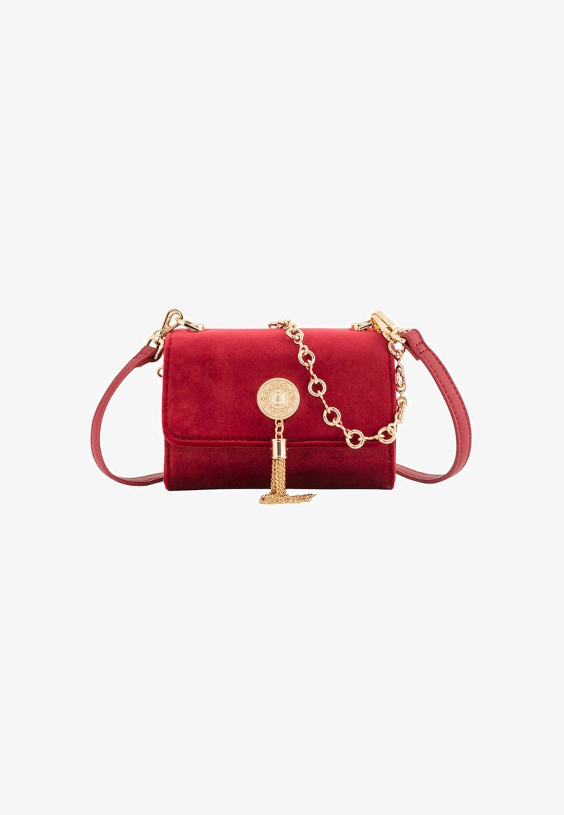 Sac bandoulière en velours rouge avec des accents en chaîne dorée, featuring un fermoir en logo circulaire et un détail de frange. Texture lisse et design compact.
