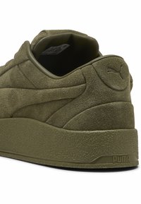 Olivgrüne Wildledersneaker mit strukturiertem Zwischensohle, gepolstertem Kragen und Logodetail an der Ferse. Merkmale geschwungene Designlinien im Obermaterial.