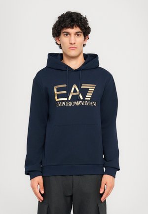 Marineblå hettegenser med gull "EA7 Emporio Armani" logo, frontlomme i kenguru-stil og ribbestrikkede mansjetter og nederkant. Myk tekstur.