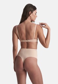 Nagie braletka i majtki w wysokim stanie. Materiał wydaje się gładki, z regulowanymi ramiączkami i zapięciem na haczyk. Czysty, minimalistyczny design.