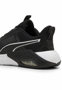 Pantof black de sport cu superior din plasă, panouri laterale texturate, accente albe și o unitate de umplere cu aer vizibil în talpă.