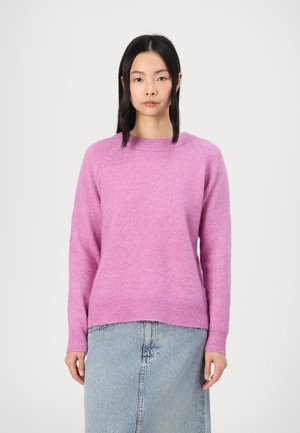 Pull en tricot rose avec un col rond, des poignets et un ourlet côtelés, texture douce, associé à une jupe en denim. Design simple et minimal.