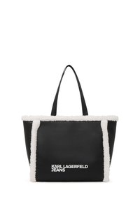 Černá taška s bílým umělým kožešinovým lemem a bílým logem "KARL LAGERFELD JEANS" na přední straně, s dvěma černými ramenními popruhy.