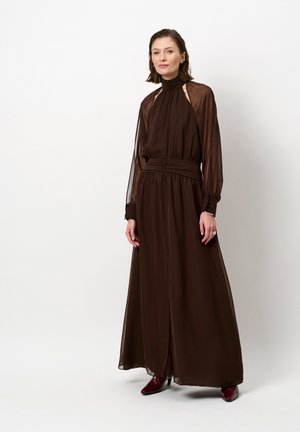 Braunes langärmliges Kleid aus leichtem Stoff mit hohem Kragen und geraffter Taille, das transparente Ärmel und einen Seitenschlitz aufweist.