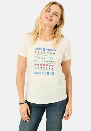 White cotton t-shirt featuring colorful floral patterns, including blue flowers and red hearts, with the text "EN FLEUR" centered on the front.