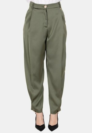 Pantaloni verde oliva a vita alta con vestibilità affusolata, pince, chiusura con bottoni e zip alle caviglie, abbinati a décolleté nere con punta affilata.
