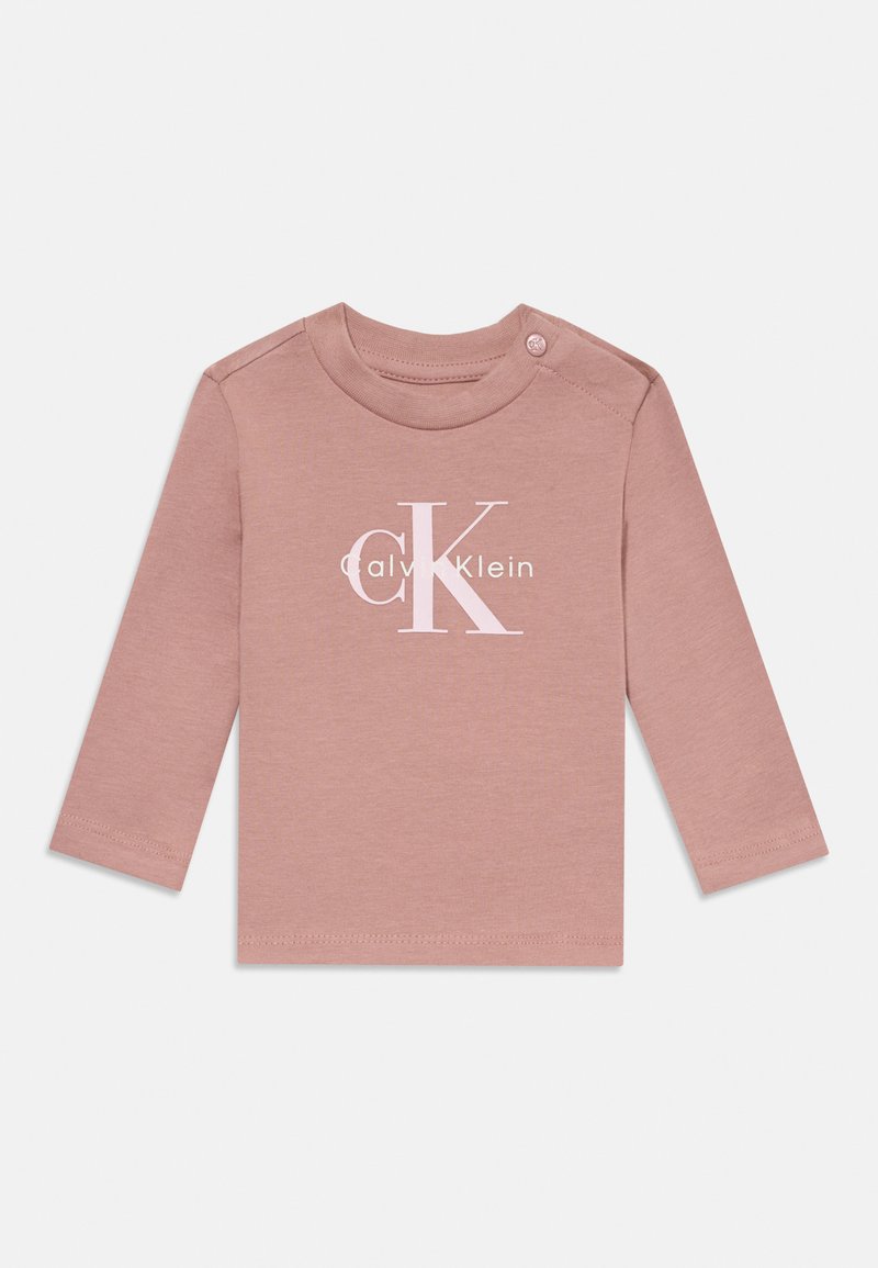 Ilgi piedurkņu drēbes bērniem rozā krāsā ar Calvin Klein "cK" logo baltā krāsā uz krūtīm un pogu kreisajā plecā.