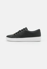 Schwarze Low-Top-Sneaker mit strukturierten Seiten, schwarzen Schnürsenkeln und weißer Sohle, die mit dem Markennamen geprägt ist, vor einem schlichten weißen Hintergrund.