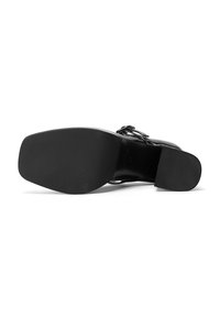 Scarpa nera con tacco alto, realizzata in pelle liscia, con punta quadrata e suola in gomma texturizzata per una migliore aderenza. Fibbia decorativa sul lato.