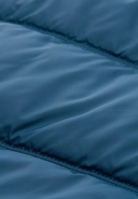 Pamučna tkanina u tamnoplavoj nijansi, sa glatkom teksturom i šivenim šavovima; lagani i vodootporni materijal, idealan za vanjsku odjeću.