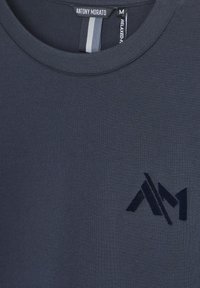 Tamno mornarsko plava majica od glatkog pamuka s opuštenim krojem, s neprimjetnim utisnutim logotipom u odgovarajućoj nijansi sprijeda.