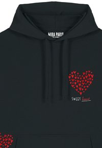 Sudadera negra con un gráfico de corazón rojo hecho de pequeños corazones. Presenta el texto "SWEET heart" en blanco. Material de algodón suave, capucha con cordón.