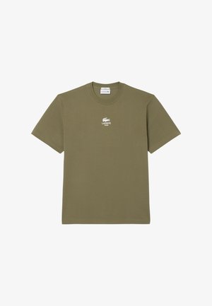 Camiseta de algodón verde oliva con cuello redondo y mangas cortas. Presenta un logo blanco de Lacoste en el pecho y un dobladillo recto.