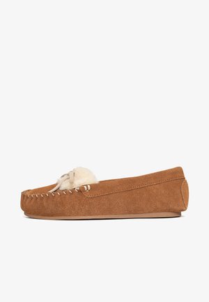 Brown suede moccasin slipper with a rounded toe, decorative stitching, and a cream-colored fur pom-pom accent on the upper.