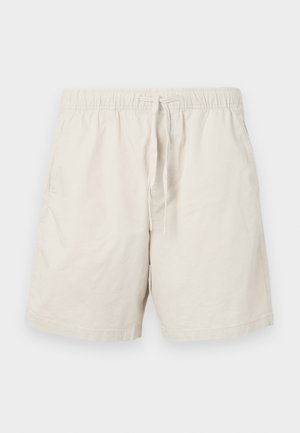 Beige cotton shorts with an elastic waistband, adjustable drawstring, and side pockets. Features a smooth, lightweight texture.