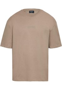 Beige cotton t-shirt with a crew neckline, short sleeves, and a subtle embossed logo on the front. Smooth texture and relaxed fit.