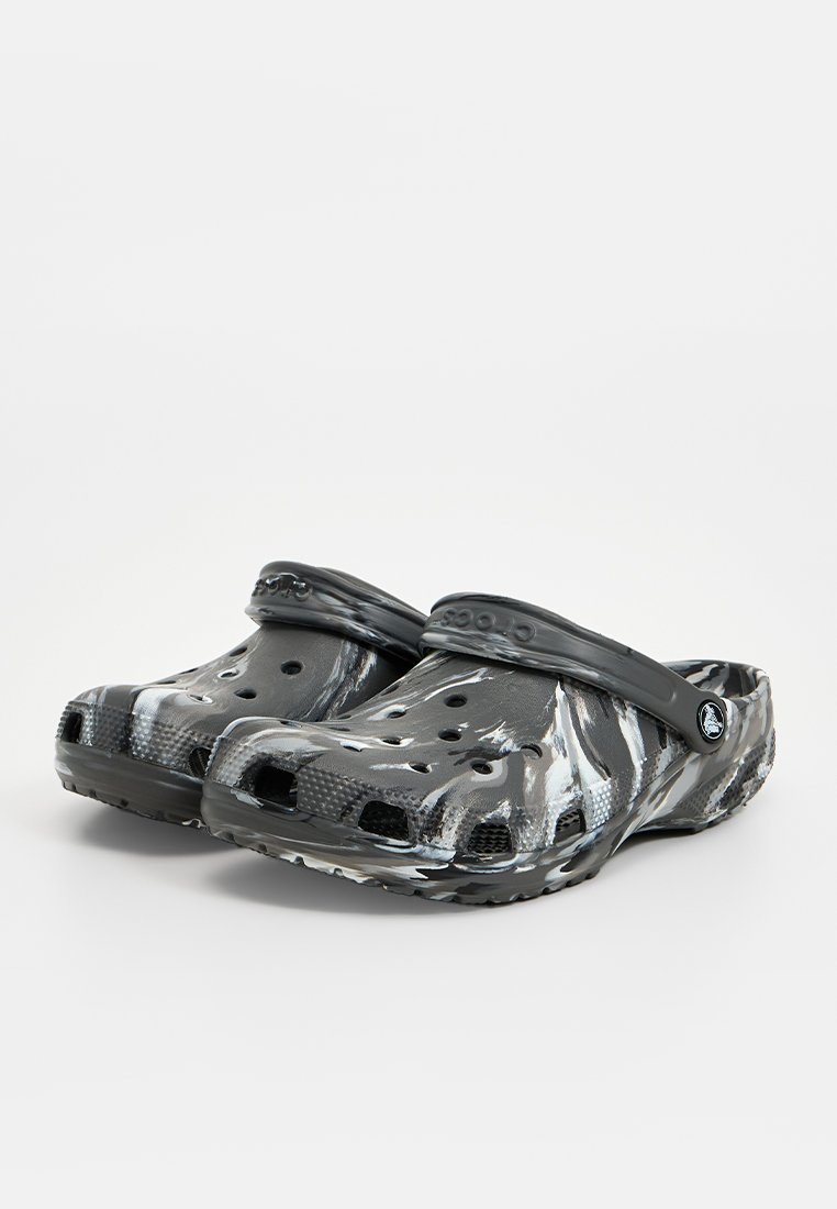 Czarno-szare klapki w wzór, wykonane z elastycznego materiału, z zaokrąglonym czubkiem, otworami wentylacyjnymi po bokach oraz tylnym paskiem zapewniającym pewne dopasowanie.