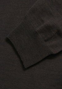 Mørkebrun strikket sweaterstof med et struktureret mønster, ribbestrik ved ærmerne og et blødt, åndbart materiale.