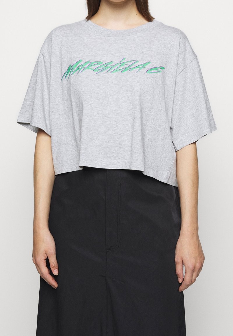 Grå kortärmad t-shirt i mjuk bomull med en djärv grön och lila grafiktext på framsidan. Löst sittande med korta ärmar.