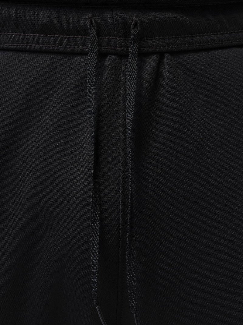 Zwarte stof met een tailleband en twee platte, gevlochten trekkoorden die in het midden naar beneden hangen.