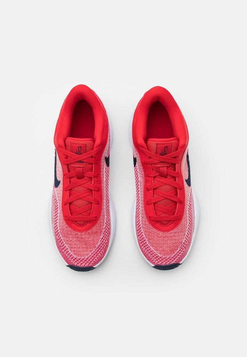 Czerwone sportowe sneakersy z teksturowanym, dzianinowym wierzchem, wyściółką kołnierza i czarnym logo swoosh, z okrągłymi sznurowadłami i białą podeszwą środkową.