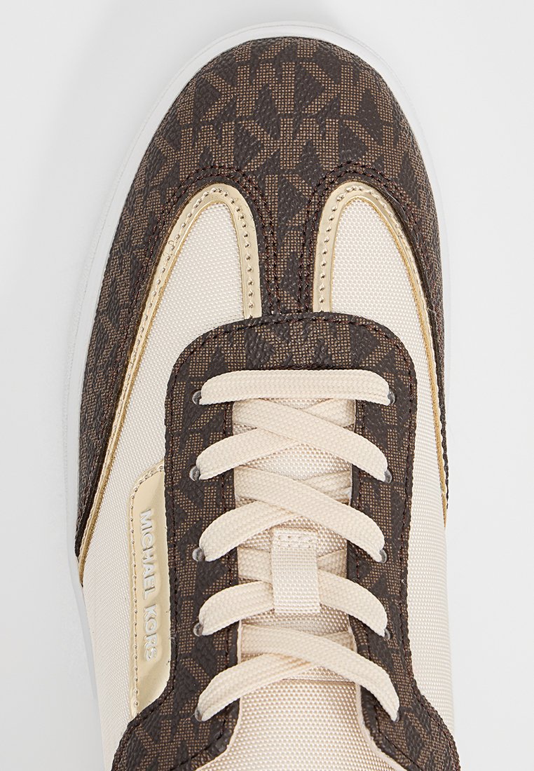 Baskets marron et beige avec un motif monogramme, en tissu lisse, à lacets, et un accent logo doré sur le côté.
