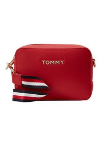 Czerwona prostokątna torba na ramię z złotym logo "TOMMY" oraz odczepianym paskiem z niebieskimi, białymi i czerwonymi paskami.