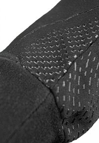 Schwarze Sportärmel mit strukturierten Mustern, die eine Kombination aus glattem und geripptem Stoff aufweisen und die feinen Nähdetails hervorheben.